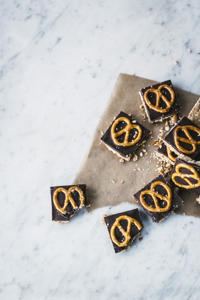 Squares of chocolate, peanut butter & pretzel bars decorated with mini pretzels
